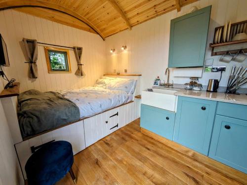 een kleine keuken met een bed en een wastafel in een kamer bij Herefordshire Escape, Hot Tub, Firepit, Views, BBQ in Leominster