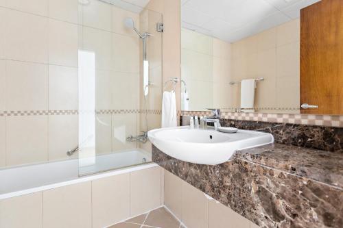 uma casa de banho com um lavatório e uma banheira em Silkhaus Modern Living Studio in Art Residence no Dubai