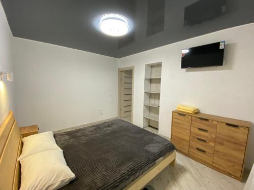 a bedroom with a bed and a tv on the wall at Vovna in Tatariv