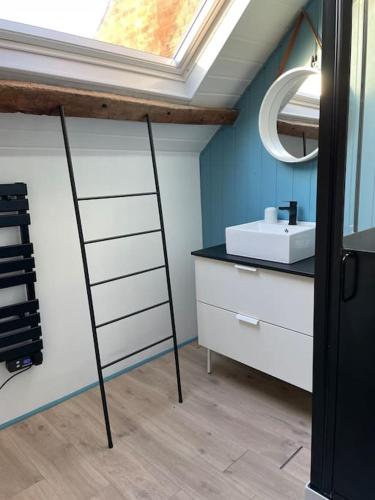 une salle de bain avec un lavabo et un miroir dans l'établissement En plein coeur du Crotoy, un pied à terre en Baie, au Crotoy