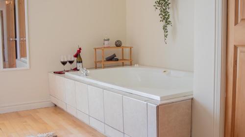 una bañera blanca con copas de vino. en Chalet BIA - Cap au Sud, en Trois-Lacs