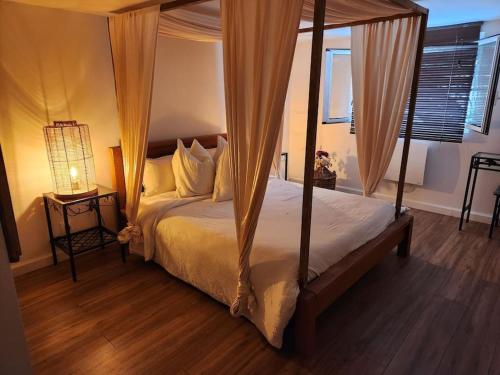 une chambre avec un grand lit à baldaquin dans l'établissement Guest house privée, à Ézanville