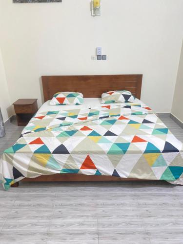 uma cama com uma colcha colorida num quarto em Chez rym 