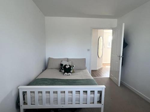 a small bedroom with a bed with a stuffed animal on it at Cosy Flat in Cambridge in Milton