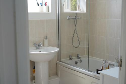 a bathroom with a sink and a shower and a sink at Cosy Flat in Cambridge in Milton