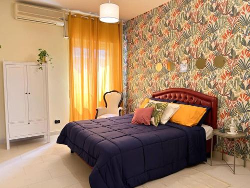 ein Schlafzimmer mit einem blauen Bett und einer farbenfrohen Wand in der Unterkunft Casa Vacanze Fabiola in Castellammare di Stabia