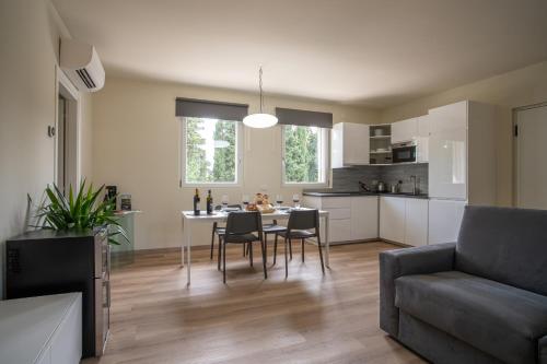 cocina y sala de estar con mesa y sillas en Hamsa Apartments AKASHA BILOCALE MODERNO en San Pietro in Cariano