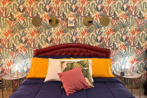 ein Schlafzimmer mit einem Bett mit bunten Kissen in der Unterkunft Casa Vacanze Fabiola in Castellammare di Stabia