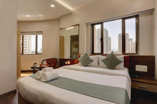 a hotel room with two beds and a large window at Hotel Ozone Inn Colaba in Mumbai