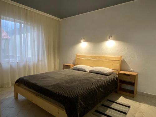 a bedroom with a bed with two pillows and a window at Vovna in Tatariv