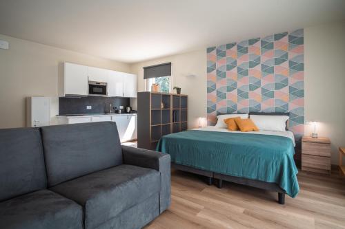 サン・ピエトロ・イン・カリアーノにあるHamsa Apartments AKASHA BILOCALE MODERNOのベッドルーム1室(ベッド1台、ソファ付)、キッチン