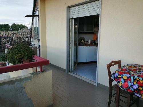 a balcony with a door open to a kitchen with a table at "vista isole EGADI" Appartamento vicino mare e aeroporto in Rilievo