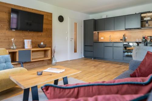 a living room with a table and a kitchen at Apartments Am Dorfplatzl in Hohentauern