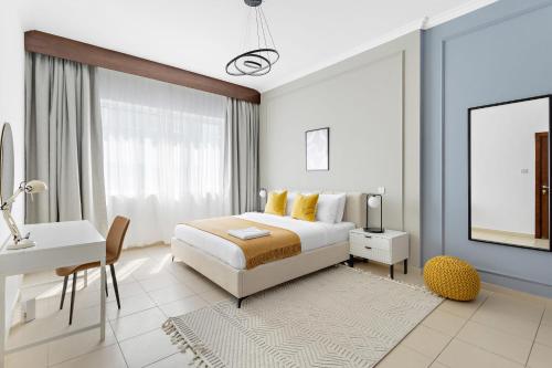 Habitación blanca con cama y escritorio en Silkhaus Furnished Pool & Gym 1BDR Art Residence en Dubái