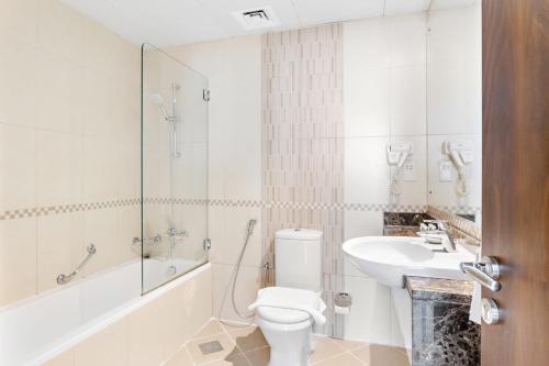 y baño con aseo y lavamanos. en Silkhaus Furnished Pool & Gym 1BDR Art Residence en Dubái