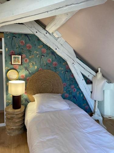 - une chambre avec un lit orné d'un mur fleuri dans l'établissement Le Petit Bois Martin, Le Controis en Sologne, à Feings