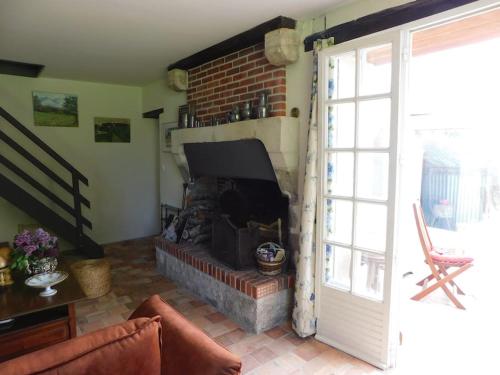 FeingsにあるLe Petit Bois Martin, Le Controis en Sologneの暖炉とレンガの壁が備わるリビングルーム