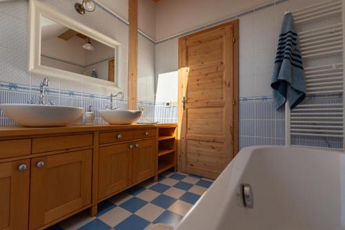 a bathroom with two sinks and a bath tub at Moderní šumavská roubenka s výhledem na Boubín in Vimperk