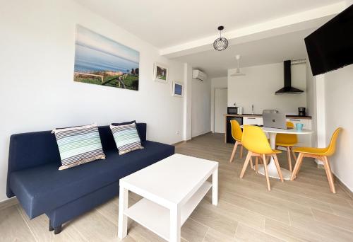 Apartamentos El Camino Resorts في كوبرسيز: غرفة معيشة مع أريكة زرقاء وطاولة