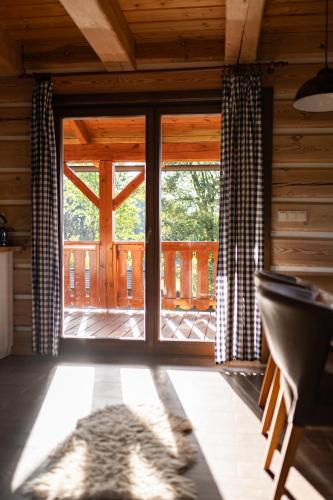a room with a large sliding glass door to a porch at Moderní šumavská roubenka s výhledem na Boubín in Vimperk