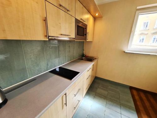 a kitchen with wooden cabinets and a sink and a window at Fantastic - Z6 Room - 702B in Warsaw