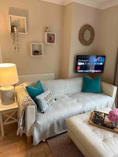 a living room with a couch and a tv at Leafy lodge in Lytham in Brown Moss Side