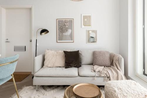 uma sala de estar branca com um sofá e uma mesa em Valoisa pikkukaksio Golf-kentän ja järven vieressä em Kirkkonummi