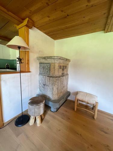 a living room with a stone fireplace and a lamp at Weissmies Lodge in Saas-Grund