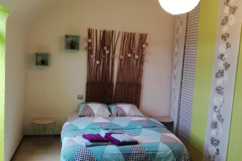 ein Schlafzimmer mit einem Bett in einem Zimmer in der Unterkunft Chez Mamilou in Soufflenheim