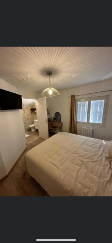 - une chambre avec un lit blanc et un plafond dans l'établissement Chambre Les gites de la Gare, à Mussidan