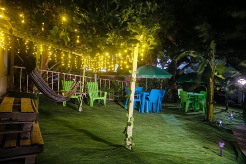 a patio with a hammock and chairs at night at Posada Hostel Adri in Providencia