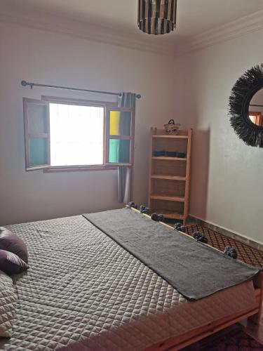 - une chambre avec un lit, une fenêtre et une étagère dans l'établissement Chez Marie, à Al Ghar