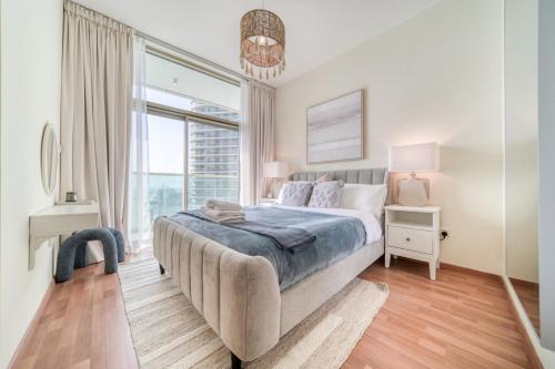 1 dormitorio con cama y ventana grande en Beach Towers A, Reem Island Abu Dhabi - Mint Stay en Abu Dabi