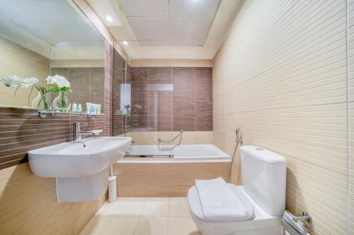 a bathroom with a toilet and a sink and a tub at Beach Towers A, Reem Island Abu Dhabi - Mint Stay in Abu Dhabi