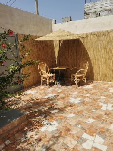 une terrasse avec des chaises, une table et un parasol dans l'établissement Chez Marie, à Al Ghar