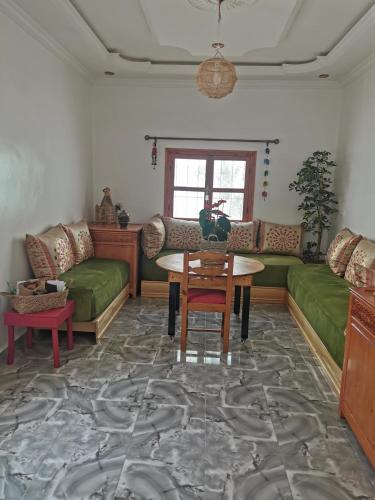 - un salon avec des canapés verts et une table dans l'établissement Chez Marie, à Al Ghar
