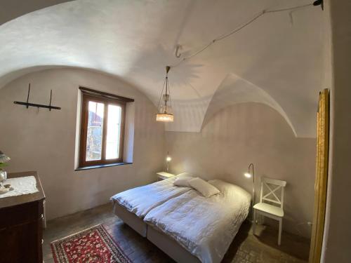 1 dormitorio con cama y ventana en Iconic Italian Townhouse w Rooftop Terrace, Pigna, en Pigna