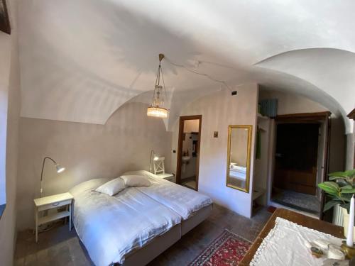 1 dormitorio con cama, mesa y espejo en Iconic Italian Townhouse w Rooftop Terrace, Pigna, en Pigna