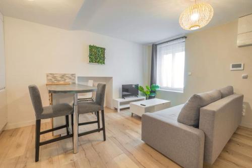 un salon avec un canapé et une table dans l'établissement Triplex cosy, à Reims