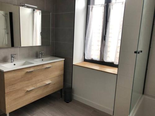 une salle de bain avec un lavabo et un miroir dans l'établissement Maison entièrement renovee, à Meyssac