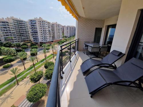 een balkon met 2 stoelen en uitzicht op de stad bij Gemelos24 Benidorm La Cala beach 200m in Benidorm