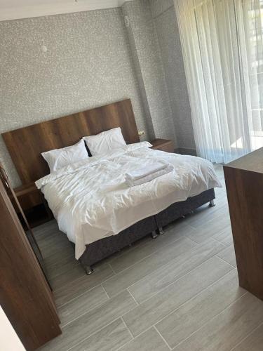1 dormitorio con 1 cama con sábanas y almohadas blancas en ege suit otel, en Bartın