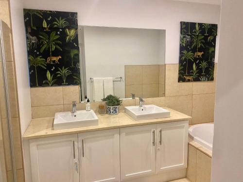 łazienka z 2 umywalkami i dużym lustrem w obiekcie WildCroft 20 w mieście Balgowan