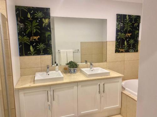 Un baño con dos lavabos y un espejo grande. en WildCroft 20, en Balgowan