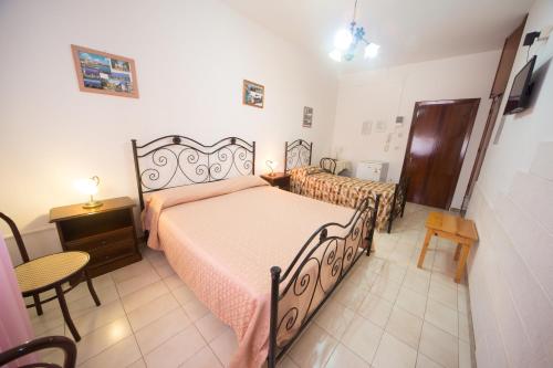 a bedroom with a bed and a table and chairs at Albergo Europa in Marina di Mancaversa