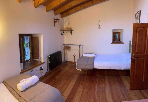 1 dormitorio con 2 camas y suelo de madera en Casa El Nogal, en Los Pandos