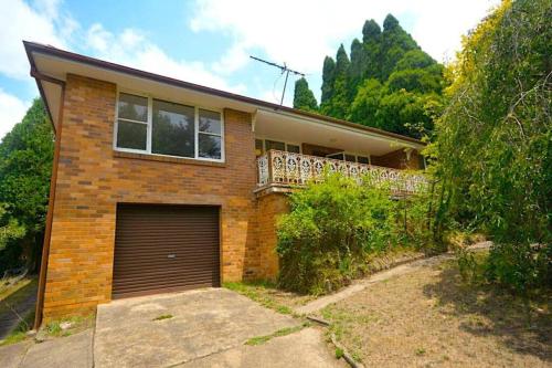 a brick house with a garage in front of it at Mount St. Raphael's in Leura