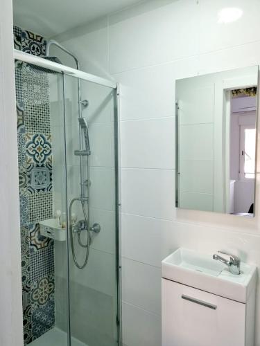 bagno con doccia, lavandino e specchio di Apartamentos T5 Valencia a Torrent