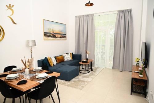 a living room with a blue couch and a table at 1BR Oasis at Starry Yas Supernova Apartment in Abu Dhabi