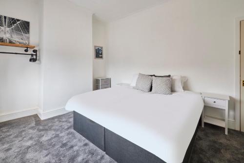 Un dormitorio blanco con una gran cama blanca. en Host & Stay - Church Street, en Golborne